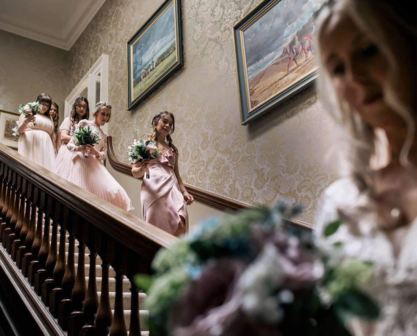 Bridesmaids descend stairwell at Kirtlington Park