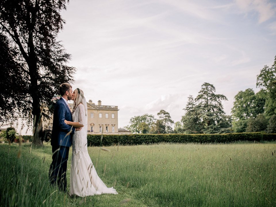 Wedding couple pose in the grounds of a beautiful palladian house in Oxfordshire on her wedding day